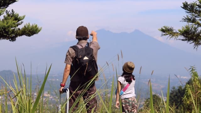 ola dan ayah menikmati pemandangan dari atas bukit